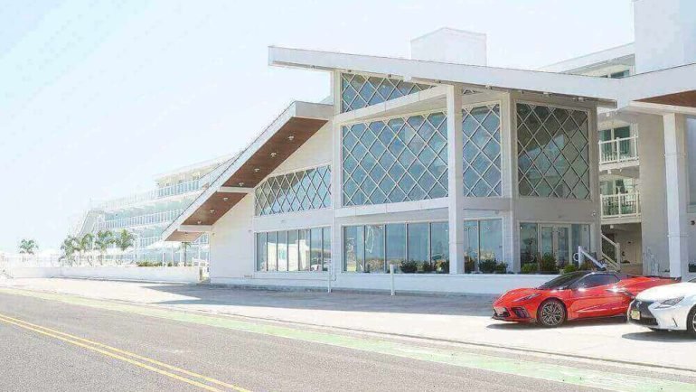 Madison Resort Wildwood Crest Contemporary glass facade with stylish red and white cars along a city street and parking area